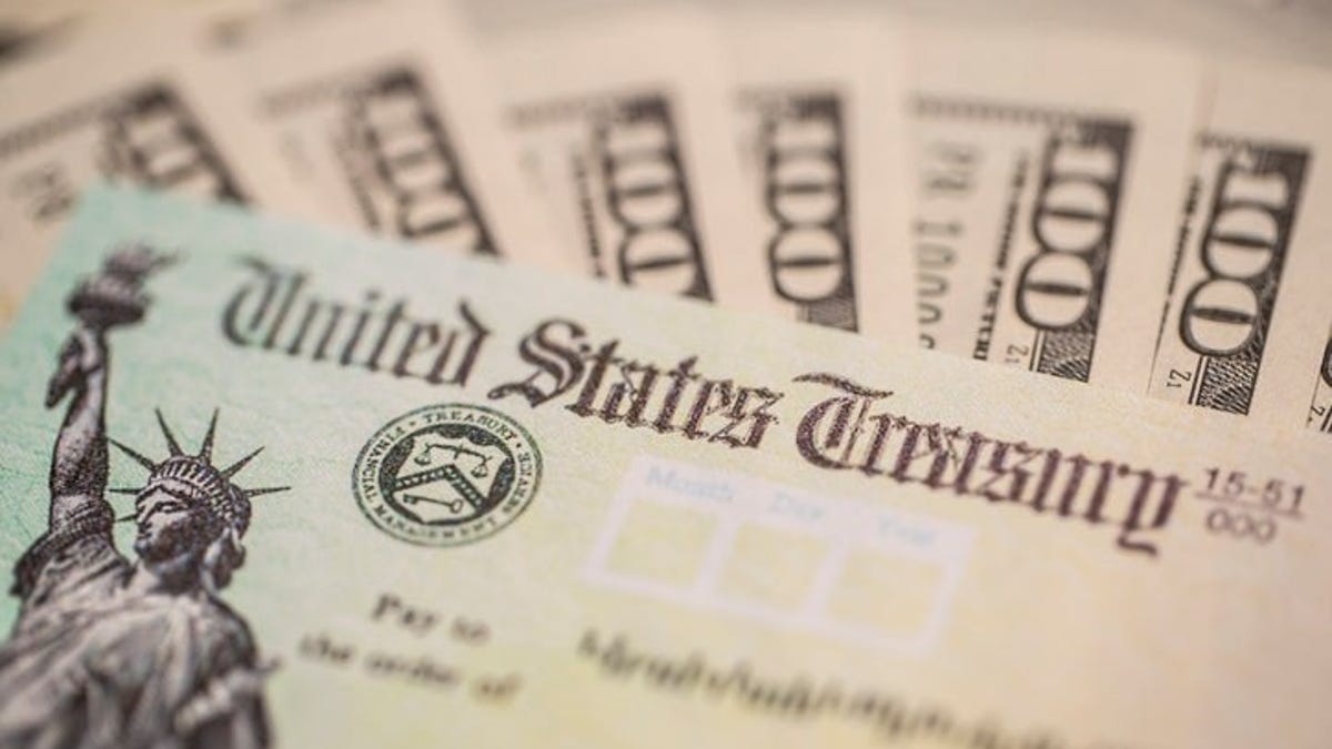 $100 bills surround a stimulus check from the U.S. Treasury