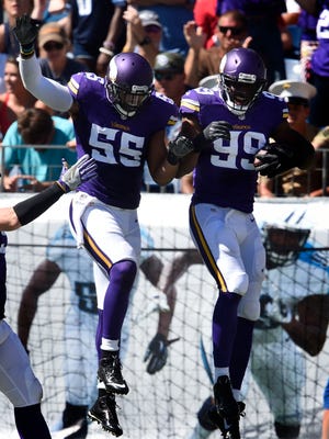 Vikings outside linebacker Anthony Barr (55) and defensive end Danielle Hunter (99) celebrate in the end zone after Hunter's interception return for a score.