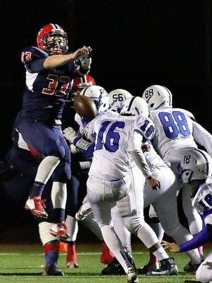 Frankln's Rob Erwin busts through Salem's offensive line to block a kick.
