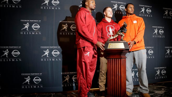 Heisman Trophy finalists, from left to right, Alabama's Derrick Henry, Stanford's Christian McCaffrey and Clemson's Deshaun Watson pose for a photo with the Heisman Trophy, Friday, Dec. 11, 2015, in New York. (AP Photo/Julie Jacobson) 