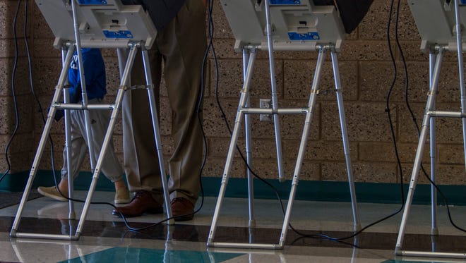 A man casts his ballot at Canyon View High School, Tuesday, Nov. 3, 2015.