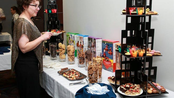 A guest surveys the choices at the 2017 Dreams to Reality event's dessert bar, which featured Girl Scout Cookies, a fruit pizza made with Caramel deLites, and other dessert options.