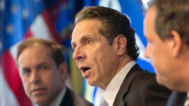 New York Governor Andrew Cuomo, center, speaks at a news conference Friday in New York. At left is Dr. Howard Zucker, acting commissioner of the New York State Department of Health, and New Jersey Governor Chris Christie is at right. The governors announced a mandatory quarantine for people returning to the United States through airports in New York and New Jersey who are deemed "high risk." In the first application of the new set of standards, the states are quarantining a female healthcare worker returning from Africa who took care of Ebola patients.