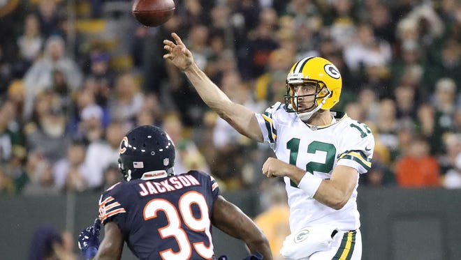 Green Bay Packers quarterback Aaron Rodgers (12) throws on the run over free safety Eddie Jackson (39) Thursday, September 28, 2017 against the Chicago Bears at Lambeau Field in Green Bay, Wis.