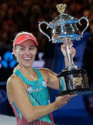 Angelique Kerber of Germany holds the trophy after defeating Serena Williams in the women's singles final.