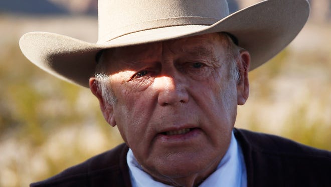 In a Wednesday, Jan. 27, 2016 file photo, rancher Cliven Bundy speaks to media while standing along the road near his ranch, in Bunkerville, Nev. A federal grand jury in Nevada indicted Cliven Bundy and four others Wednesday, Feb. 17, 2016, on 16 charges related to an armed standoff near his ranch in 2014 over unpaid grazing fees. Bundy is accused of leading "a massive armed assault" of 200 followers to stop federal law agents who were rounding up about 400 of Bundy's cattle on federal lands in April 2014, according to documents filed by U.S. attorneys Wednesday.