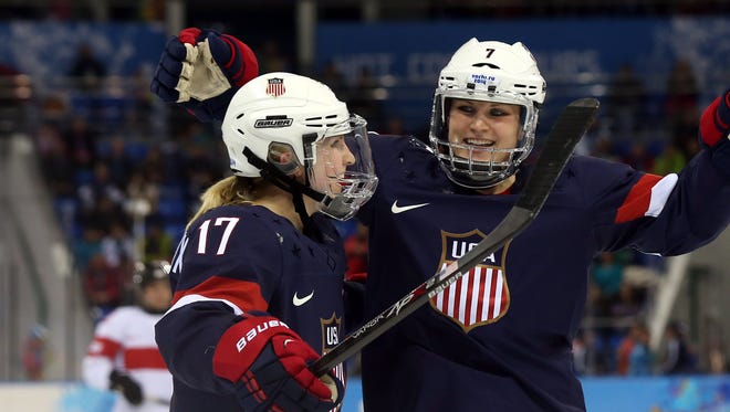 USA forward Monique Lamoureux-Morando (7) celebrates with forward Jocelyne Lamoureux-Davidson (17) after scoring a goal against Switzerland in a women's preliminary round game during the 2014 Sochi Olympics.