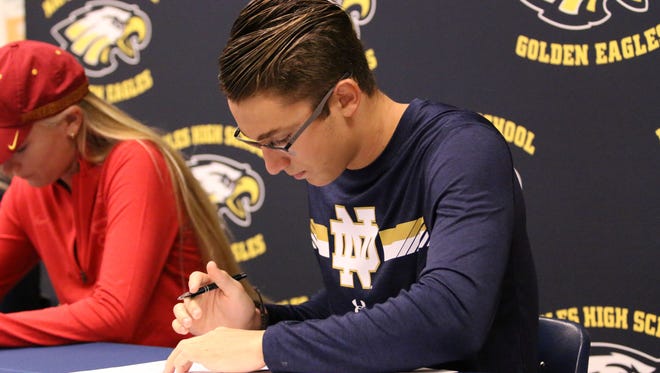 Naples swimmer Matthew Limbacher signs his letter of intent to swim at Notre Dame during the early signing period in the Naples High School cafeteria on Tuesday, Nov. 11, 2017.