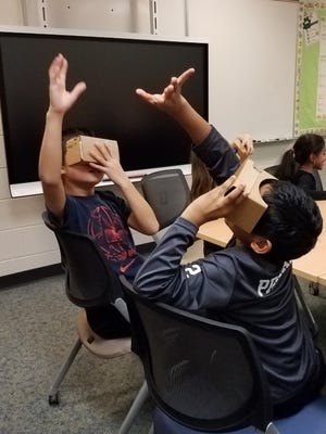 Teacher Michelle Donberger explains Google Cardboard: “When you’re looking down, you see the grass below your feet. Looking up, you see the sky above your head. Spin in a circle, you see the full 360.”