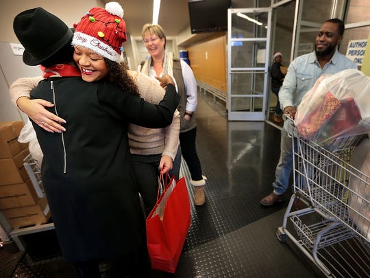 MIFA volunteer Victoria Vicks hugs members of the MIFA staff as she and her foster mother Tammera Freno pick up meals for delivery. MIFA volunteers delivered over 800 Christmas meals this year.