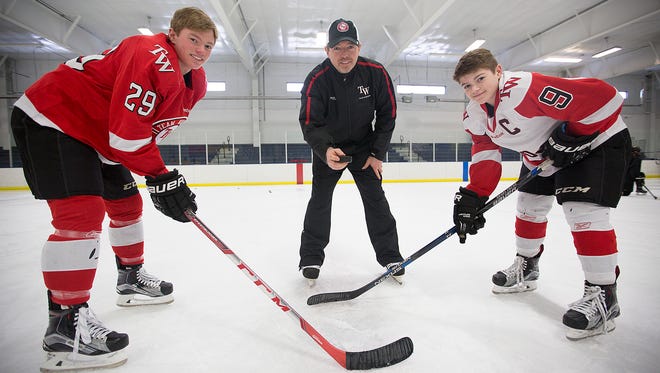 Paul Caufield, center, presides over a face-off between his sons Brock, left, and Cole, right, at Ice Hawks Arena in Stevens Point, Thursday, Feb. 25, 2016. Paul Caufield is the all-time career scoring leader in UWSP hockey history, while both his sons have committed to play hockey at the Ohio State University.