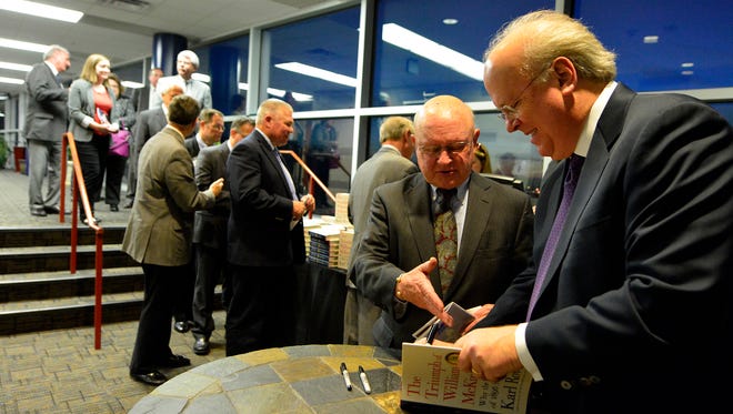 Karl Rove, right, signs his book for Reed Anderson of Newpark following the Manufacturer's Association's annual event at the Pullo Center, Wednesday, April 20, 2016. John A. Pavoncello photo