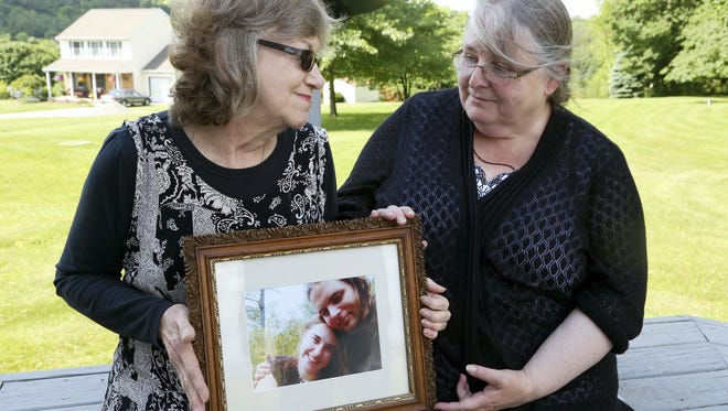 Lyn Coleman and Linda Boyle hold a picture of the children, Caitlan Coleman and Joshua Boyle, who are held captive by Taliban, as they sit outside of the Coleman's house in Stewartstown in this 2014 photo.