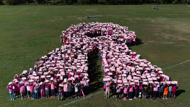 Over 850 students and staff make Thorne Middle School Pink Ribbon for Breast Cancer Awareness