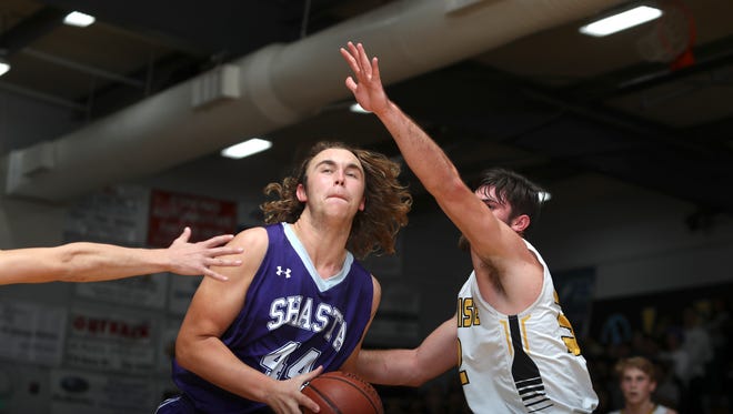 Shasta High’s Tanner Williams (left) drives the ball while being guarded by Enterprise’s Joe Spini (right) during the Harlan Carter tournament Friday night. Shasta won 61-43.
