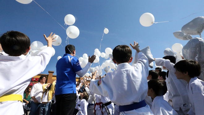 Children from the OTT Martial Arts School at 810 Redd Road let fly white balloons outside the school in memory of Adrian Moreno Quiñonez on Saturday in West El Paso. Quiñonez, who was a martial arts coach at the school was the victim of a gun related attack in Juárez last weekend.