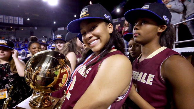 Riverdale's Brinae Alexander (32) holds the championship trophy with her teammate Aislynn Hayes (11) behind her as the team celebrates its victory over Memphis Central in the Class AAA State Tournament on Saturday, March 11, 2017.