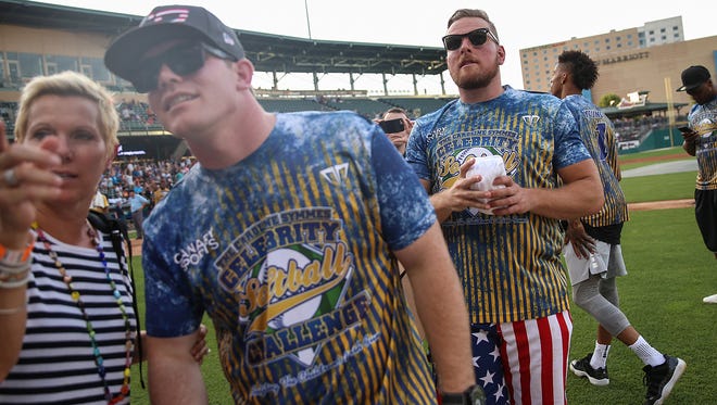 From left, Conor Daly and Pat McAfee throw tee-shirts during the 9th annual Caroline Symmes Celebrity Softball Challenge at Victory Field in Indianapolis, Thursday, June 15, 2017. 