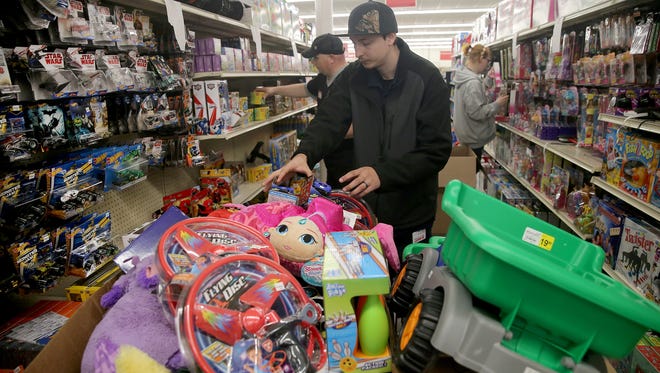 Bi-Mart employee Trevor Wershing puts out toys at the new store location on Olney and Mill Hill Drive in Port Orchard on Friday. The store is a membership discount store in Washington, Oregon, and Idaho.