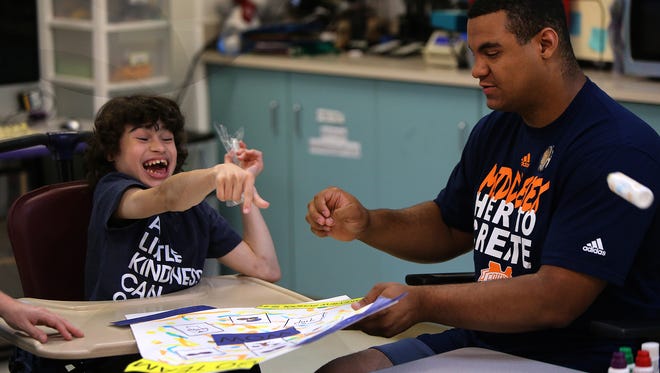 Branden Barnes, a recent Edison High School graduate, interacts with Tanner Mercado from Edison during the Middlesex County All-Stars' visit to the Lakeview School in Edison on Monday.
