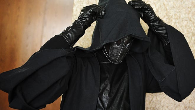 Shaun Schreiner, of Sioux Falls, who was dressed as a Sith Lord, adjusts his costume during SiouxperCon Saturday, April 16, 2016, at the Best Western Plus Ramkota Hotel in Sioux Falls. 