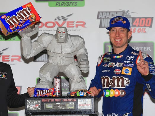 Kyle Busch shares a packet of caramel M&Ms with mascot