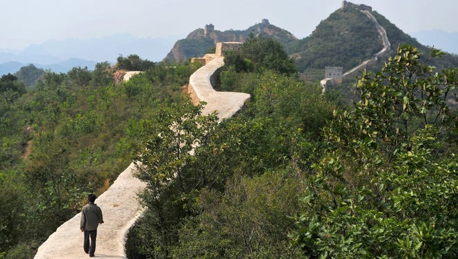 A villager walks across a restored section of the Great Wall in Suizhong County in northeastern China's Liaoning Province on Wednesday, Sept. 21, 2016.