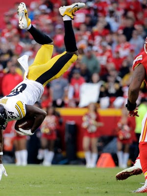 Kansas City Chiefs linebacker Derrick Johnson, right, watches as Pittsburgh Steelers wide receiver Antonio Brown (84) is flipped by a tackle by Chiefs linebacker Kevin Pierre-Louis during the second half of an NFL football game in Kansas City, Mo., Sunday, Oct. 15, 2017. (AP Photo/Charlie Riedel)