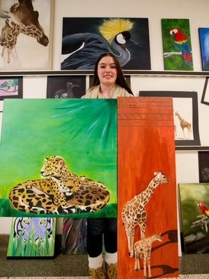 Josephine Lee holds two of her paintings which are in the annual art show at Abilene High School Monday, Nov. 7, 2016.