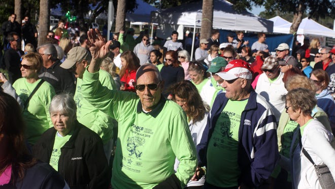 Walter KIngman waves as he starts off near the front of  the Harry Chapin Food Bank walk to raise money Saturday at Miromar Outlets in Estero. Hundreds participated in the annual event to raise money for the hungry in Southwest Forida.