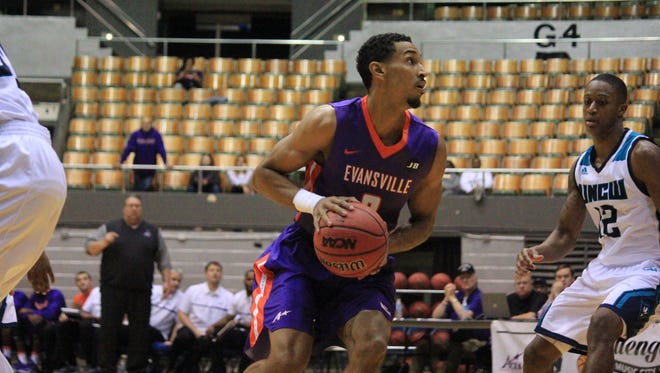 Evansville sophomore Ryan Taylor turns to look for his shot in front of UNC Wilmington sophomore C.J. Bryce during their game Saturday at the Nashville Municipal Auditorium.