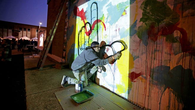 Aritist Irineo Medina works on a mural just off Wisconsin Avenue during Bazaar After Dark on Sept. 28, 2016.