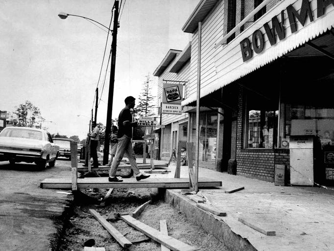 Shoppers cross makeshift bridges to reach stores on