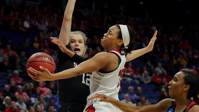 Louisville's Asia Durr splits two Stanford defenders to make an acrobatic shot.  