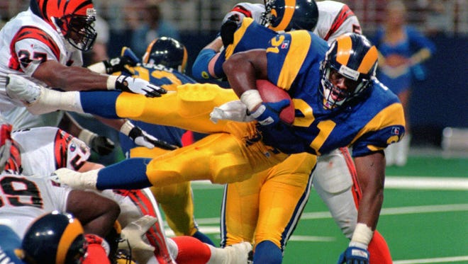 FILE - This Sunday, Sept. 1, 1996,  file photo shows St. Louis Rams running back Lawrence Phillips (21) leaping over a mound of players as he scores against the Cincinnati Bengals in St. Louis, Mo. Former NFL running back, Phillips was found dead in his California prison cell early Wednesday, Jan. 13, 2016, and officials said they suspect suicide.