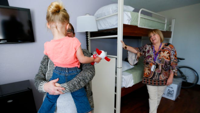 Esther Munch, Harmony House marketing director, holds the daughter of a resident of Harmony House as Lisa Farmer, Harmony House executive director, look on in a new resident room on Thursday, Feb. 16, 2017.
