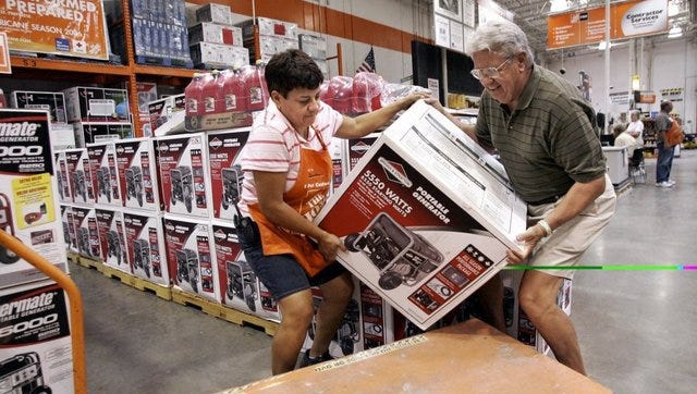 Naples resident Bob Frederiksen loads a generator onto a dolley for purchase with the assistance of employee Jeanette Thevning at the Bonita Springs Home Depot on Thursday, the last day to purchase hurricane supplies tax-free.