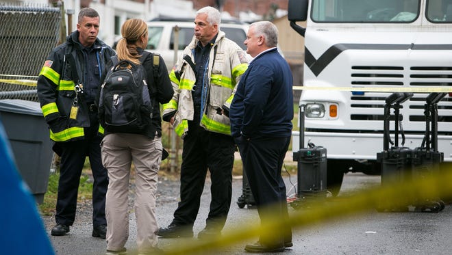 Mike Donohue (second from right), Deputy Chief at Wilmington Fire Department, along with other investigators gather Thursday on scene of the house fire at the Canby Park rowhome that killed two Wilmington firefighters and injured five others early Saturday.