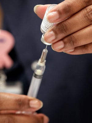 A health professional prepares to give a vaccination.