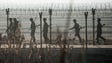 North Korean soldiers patrol next to the border fence