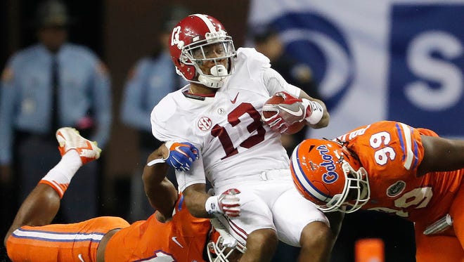 Alabama wide receiver ArDarius Stewart (13) is hit by Florida defensive lineman Jachai Polite (99) and Florida linebacker Daniel McMillian (13) during the second half of the Southeastern Conference championship NCAA college football game, Saturday, Dec. 3, 2016, in Atlanta.(AP Photo/John Bazemore)