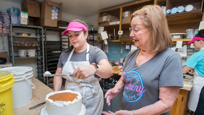 Owner Frances Michener, right, gives a few pointers to Caitlin Floyd as she frosts a cake at the Milton Quality Bakery in Milton on Monday, May 14, 2018.  The bakery, which is competing in the "Sweetest Bakery in America Contest", currently has the second most votes in the state of Florida.