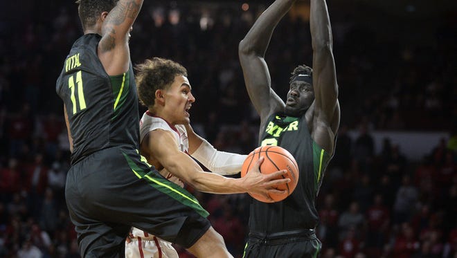 Oklahoma Sooners guard Trae Young (11) drives to the basket between Baylor Bears forward Mark Vital (11) and Baylor Bears forward Jo Lual-Acuil Jr. (0) during the second half at Lloyd Noble Center.