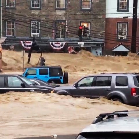 Water rushes through Main Street in Ellicott...