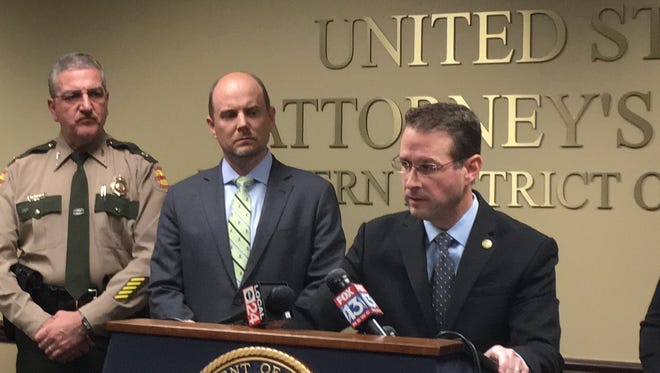 Robert Hammer (center) flanked U.S. Atty. D. Michael Dunavant (at podium) during a news conference announcing federal charges in the Nov. 28 arrests of immigrants at Expeditors International.