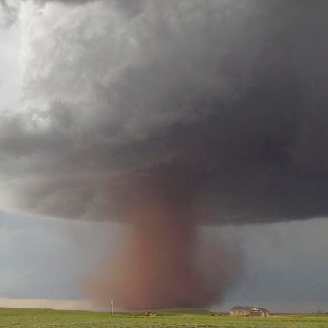 A tornado move slowly across the plains north of...