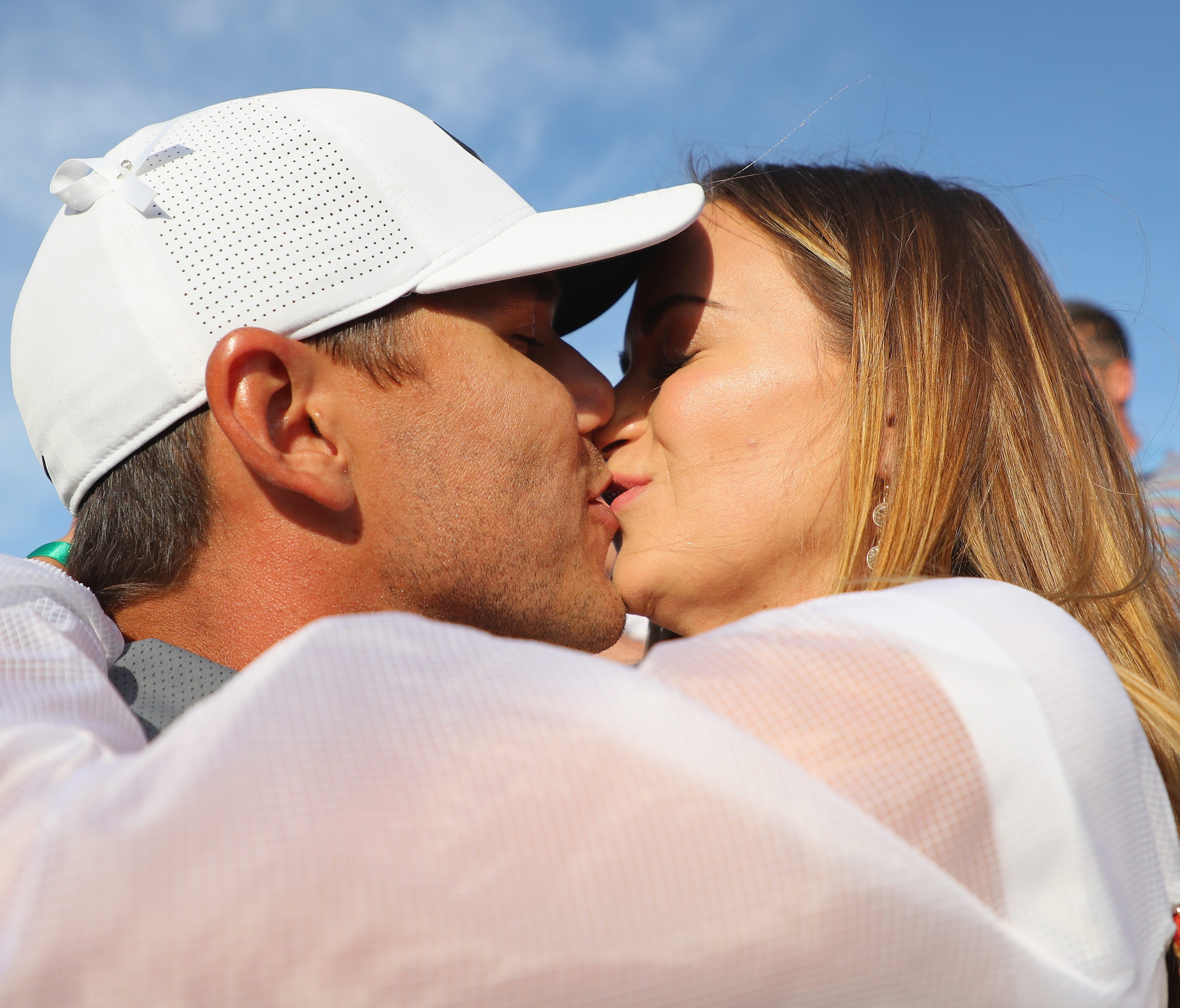 Brooks Koepka kisses girlfriend Jena Sims after winning the U.S. Open on Sunday at Shinnecock Hills. Koepka shot a final-round 68 to finish the tournament at 1 over par, one shot better than Tommy Fleetwood.