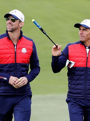 Olympic swimmer Michael Phelps and surfer Kelly Slater walk up a fairway during the 2016 Ryder Cup Celebrity Matches at Hazeltine National Golf Club on Sept. 27 in Chaska, Minn.