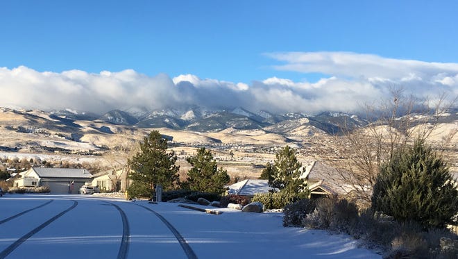 Clouds cover Mount Rose south of Reno on Sunday morning as a couple inches of snow blanket the Virginia Foothills neighborhood.