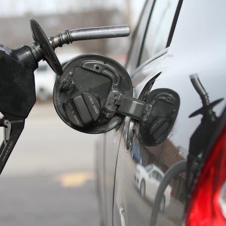A driver fills up her gas tank.
